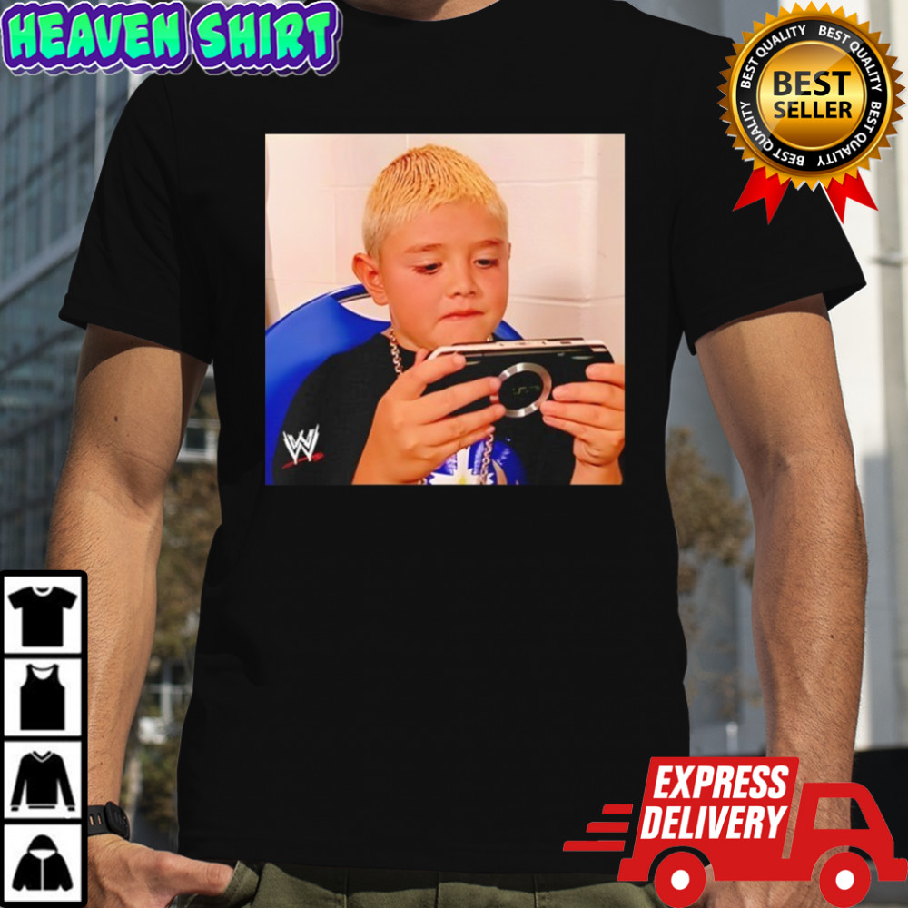 Dominik Mysterio wearing his younger self playing the PSP shirt